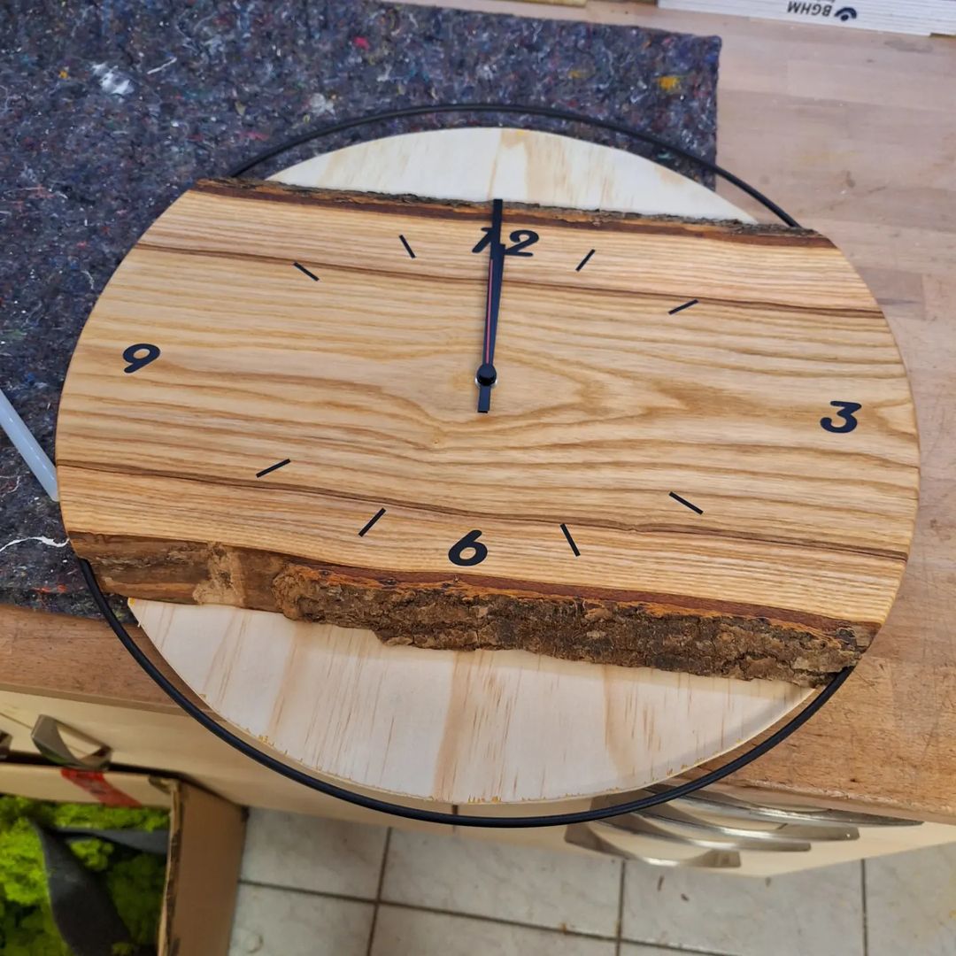 A rustic wooden clock with visible tree bark edge