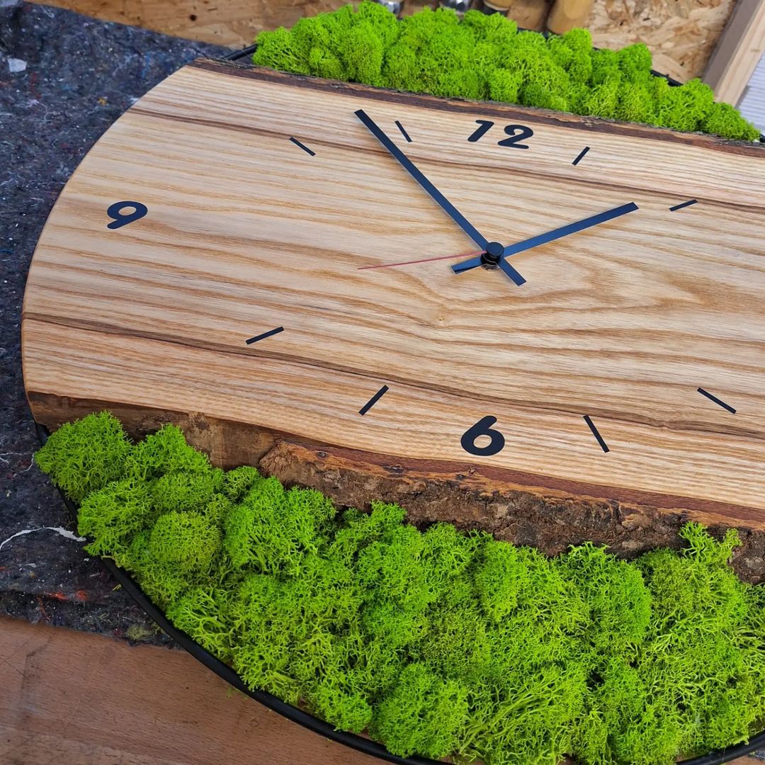 A unique wooden clock design with vibrant green moss detailing