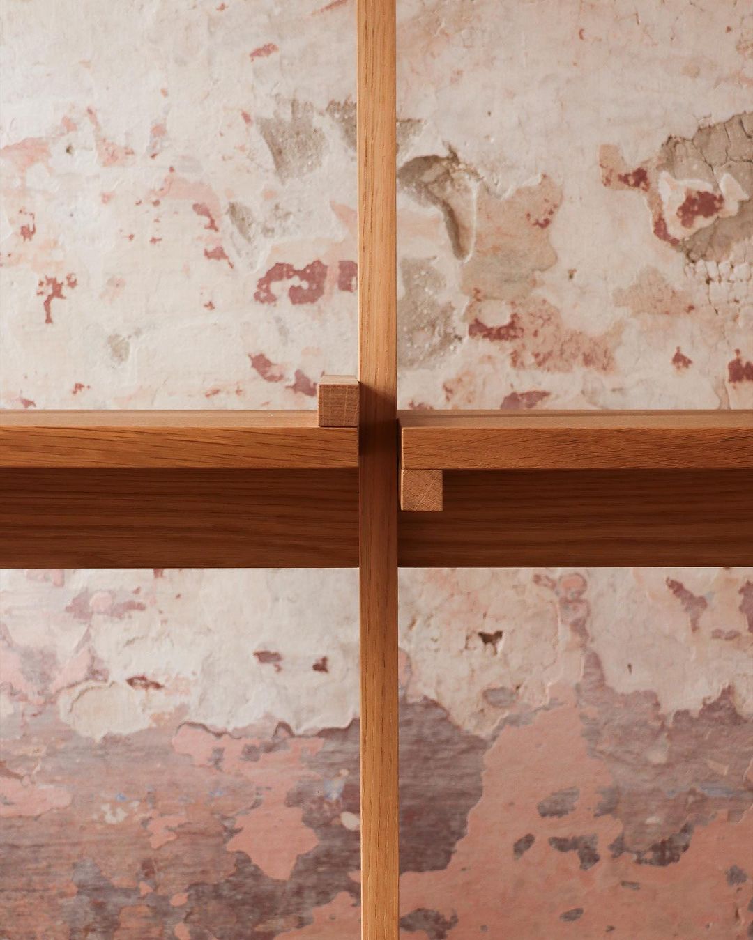 Wooden cross against a textured wall