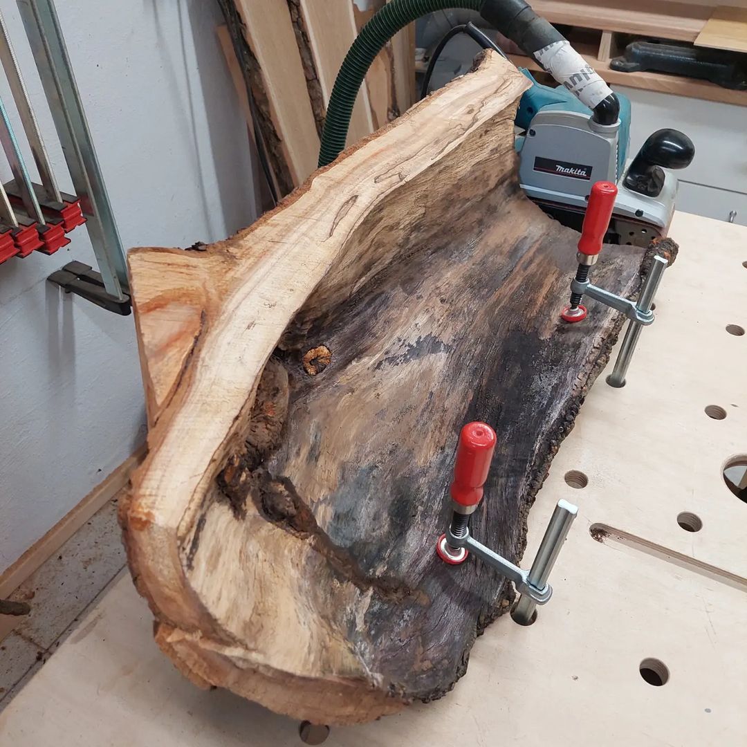 A piece of wood being worked on with hand tools and clamps