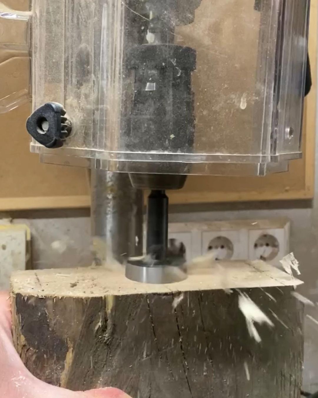 A craftsman using a plunge router on a piece of wood