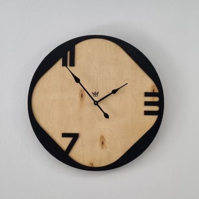 A minimalist wooden wall clock with black accents