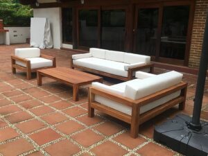 Outdoor wooden furniture set on a terracotta tiled patio