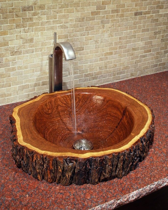 A unique wooden sink in the form of a large polished tree section